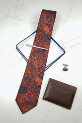 Orange paisley pattern silk tie with standard width for formal events.
